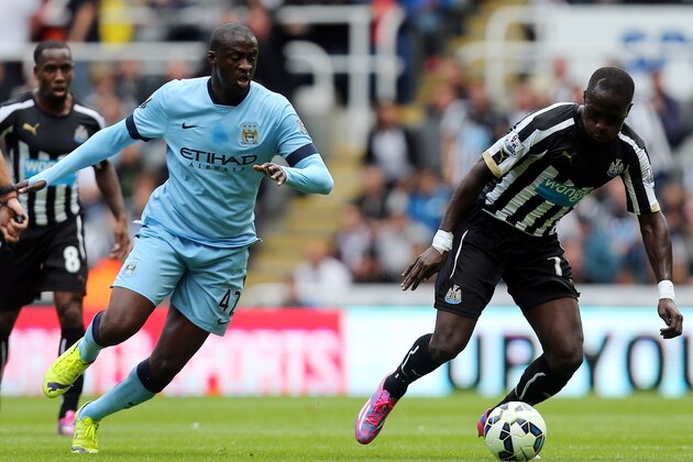 Newcastle United's Moussa Sissoko, right, vies for the ball with Manchester City's Yaya Toure, left, during their English Premier League soccer match at St James' Park, Newcastle, England, Sunday, Aug. 17, 2014. (AP Photo/Scott Heppell)