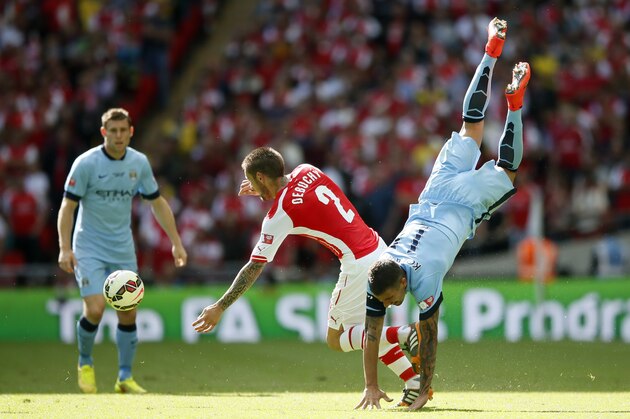 Arsenal's Mathieu Debuchy, left, clashes with a falling Manchester City's Aleksandar Kolarov during the English FA Community Shield soccer match at Wembley Stadium, London Sunday, Aug. 10, 2014. (AP Photo/Alastair Grant)