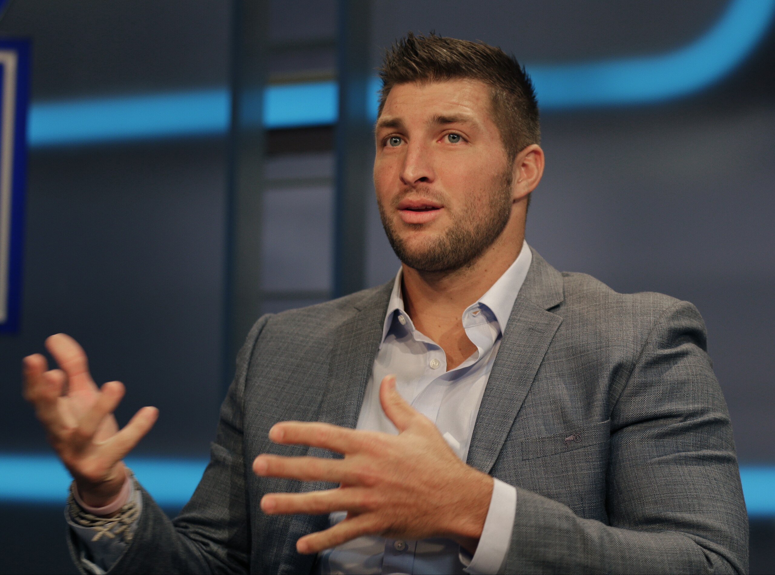 Tim Tebow answers a question during a interview on the set of ESPN's new SEC Network in Charlotte, N.C., Wednesday, Aug. 6, 2014. Tebow has a new job as a commentator for the SEC Network, but is still looking for work in the NFL as a quarterback. (AP Photo/Chuck Burton)