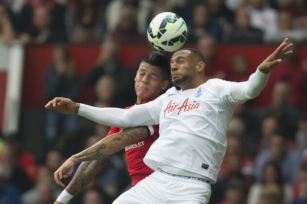 Manchester United's Marcos Rojo, left, fights for the ball against Queens Park Rangers' Matt Phillips during their English Premier League soccer match at Old Trafford Stadium, Manchester, England, Sunday Sept. 14, 2014. (AP Photo/Jon Super)