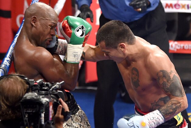 LAS VEGAS, NV - SEPTEMBER 13:  Marcos Maidana (R) hits Floyd Mayweather Jr. with a right in the fourth round of their WBC/WBA welterweight title fight at the MGM Grand Garden Arena on September 13, 2014 in Las Vegas, Nevada. Mayweather Jr. won by unanimous decision.  (Photo by Ethan Miller/Getty Images)