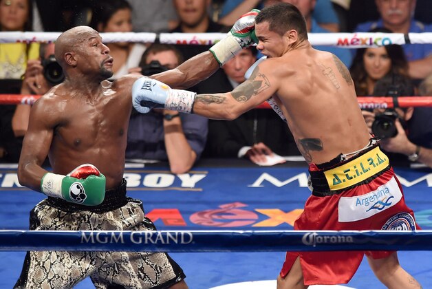 LAS VEGAS, NV - SEPTEMBER 13:  Floyd Mayweather Jr. (L) hits Marcos Maidana with a left in the fourth round of their WBC/WBA welterweight title fight at the MGM Grand Garden Arena on September 13, 2014 in Las Vegas, Nevada. Mayweather Jr. won by unanimous decision.  (Photo by Ethan Miller/Getty Images)