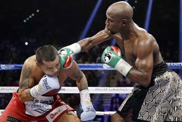 Floyd Mayweather punches Marcos Maidana, left, during their WBA welterweight and WBC super  welterweight title fight, Saturday, Sept. 13, 2014, in Las Vegas. (AP Photo/John Locher)