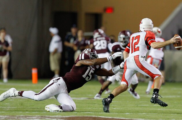 COLLEGE STATION, TX - SEPTEMBER 06:  Caleb Berry #12 of the Lamar Cardinals avoids a tackle attempt by Myles Garrett #15 of the Texas A&M Aggies at Kyle Field on September 6, 2014 in College Station, Texas.  (Photo by Bob Levey/Getty Images)