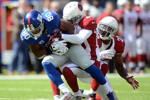 EAST RUTHERFORD, NJ - SEPTEMBER 14: Wide receiver Victor Cruz #80 of the New York Giants is tackled after making a catch against the Arizona Cardinals during a game at MetLife Stadium on September 14, 2014 in East Rutherford, New Jersey.  (Photo by Ron Antonelli/Getty Images)