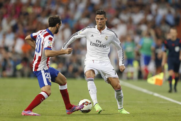 Real Madrid's Cristiano Ronaldo, right, duels for the ball with Atletico de Madrid's Juan Fran during a Spanish La Liga soccer match at the Santiago Bernabeu stadium in Madrid, Spain, Saturday, Sept. 13, 2014. (AP Photo/Daniel Ochoa de Olza)