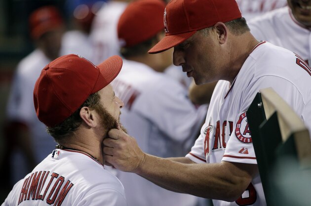 Los Angeles Angels third base coach Gary DiSarcina, right, jokingly pulls the beard of Josh Hamilton before a baseball game against the Seattle Mariners Monday, Sept. 15, 2014, in Anaheim, Calif. (AP Photo/Jae C. Hong)