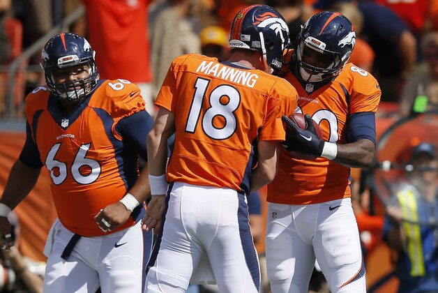 Denver Broncos quarterback Peyton Manning (18) celebrates his touchdown pass to teammates Julius Thomas as Manny Ramirez (66) looks on during an NFL football game against the Kansas City Chiefs, Sunday, Sept. 14, 2014, in Denver. (AP Photo/Jack Dempsey)