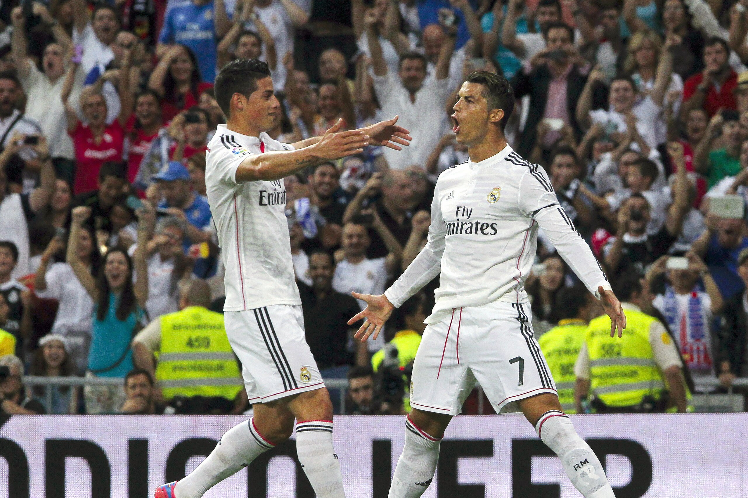 Real Madrid’s Cristiano Ronaldo, right, celebrates his goal with teammate James Rodriguez during a Spanish La Liga soccer match against Atletico de Madrid  at the Santiago Bernabeu stadium in Madrid, Spain, Saturday, Sept. 13, 2014. (AP Photo/Gabriel Pecot)