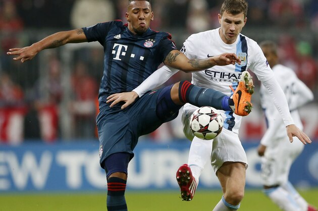 Bayern's Jerome Boateng, left, and Manchester City's Edin Dzeko challenge for the ball during the Champions League group D soccer match between FC Bayern Munich and Manchester City, in Munich, southern Germany, Tuesday, Dec. 10, 2013. (AP Photo/Matthias Schrader)