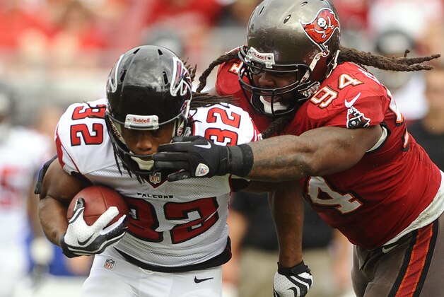 Tampa Bay Buccaneers defensive end Adrian Clayborn (94) grabs Atlanta Falcons running back Jacquizz Rodgers (32) by the facemask during the second quarter of an NFL football game Sunday, Nov. 17, 2013, in Tampa, Fla. (AP Photo/Brian Blanco)