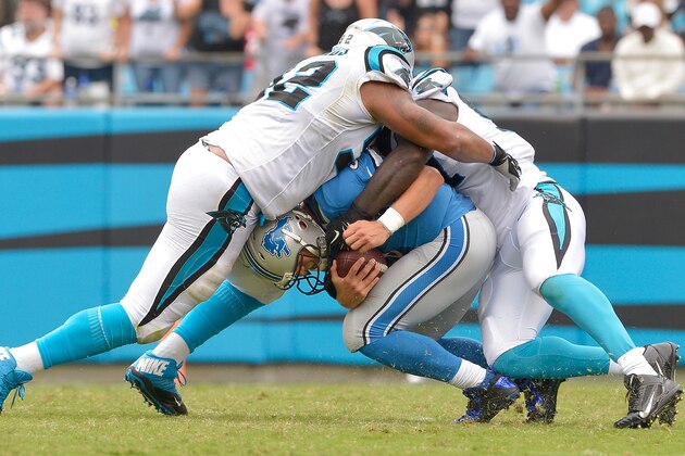 CHARLOTTE, NC - SEPTEMBER 14:  Dwan Edwards #92 and Mario Addison #97 of the Carolina Panthers sack Matthew Stafford #9 of the Detroit Lions during their game at Bank of America Stadium on September 14, 2014 in Charlotte, North Carolina. The Panthers won 24-7.  (Photo by Grant Halverson/Getty Images)