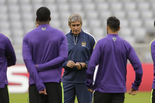 Manchester City head coach Manuel Pellegrini, center, instructs his team during a training session ahead of Wednesday's Champions League group E soccer match between FC Bayern Munich and Manchester City, in Munich, southern Germany, Tuesday, Sept. 16, 2014. (AP Photo/Matthias Schrader)