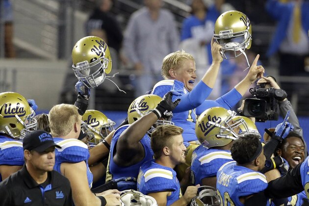 UCLA quarterback Jerry Neuheisel, top, is carried off the field after UCLA's 20-17 win over Texas in an NCAA college football game, Saturday, Sept. 13, 2014, in Arlington, Texas. (AP Photo/Tony Gutierrez)