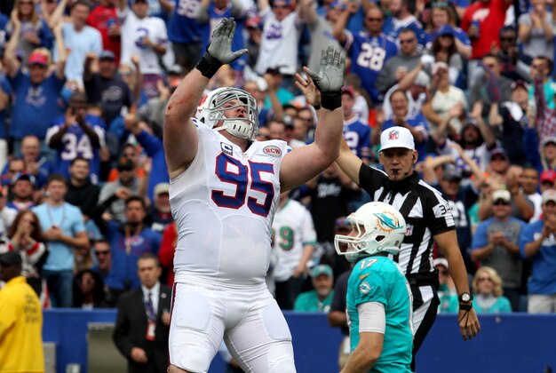 Sep 14, 2014; Orchard Park, NY, USA; Buffalo Bills defensive tackle Kyle Williams (95) celebrates a sack on Miami Dolphins quarterback Ryan Tannehill (17) during the first half at Ralph Wilson Stadium. Mandatory Credit: Timothy T. Ludwig-USA TODAY Sports