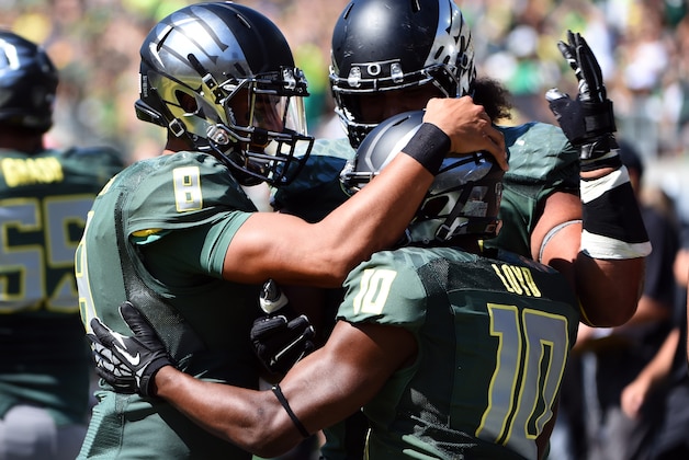 Oregon quarterback Marcus Mariota (8) celebrates with Oregon Ducks wide receiver Johnathan Loyd (10) after Loyd scored a touchdown during the third quarter of the college football game against the Wyoming at Autzen Stadium on Saturday, Sept. 13, 2014 in Eugene, Ore. (AP Photo/Steve Dykes)