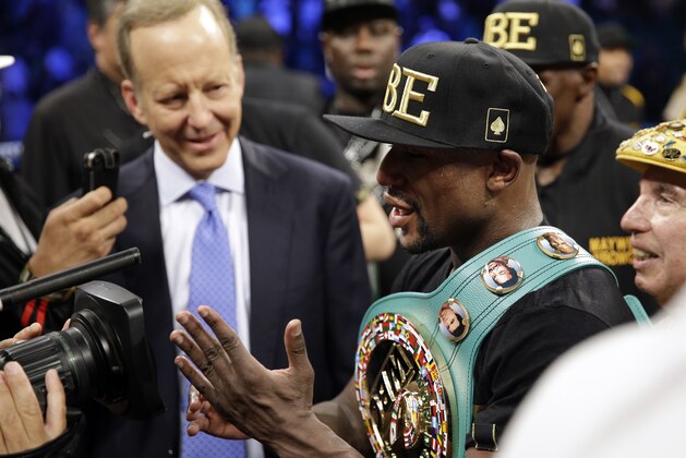 Floyd Mayweather shows the cameras his hand at the end of his fight against Marcos Maidana in a title boxing bout Saturday, Sept. 13, 2014, in Las Vegas. Mayweather claimed that Maidana bit his hand. (AP Photo/John Locher)