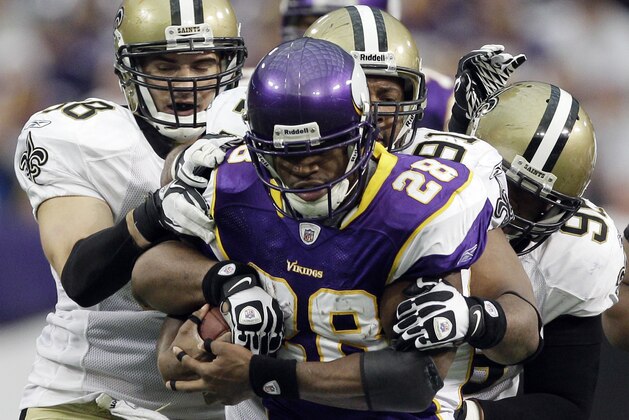 Minnesota Vikings running back Adrian Peterson (28) is stopped by New Orleans Saints' Scott Shanle (58),  Will Smith (91) and  Tom Johnson during the second half of an NFL football game Sunday, Dec. 18, 2011, in Minneapolis. (AP Photo/Morry Gash)
