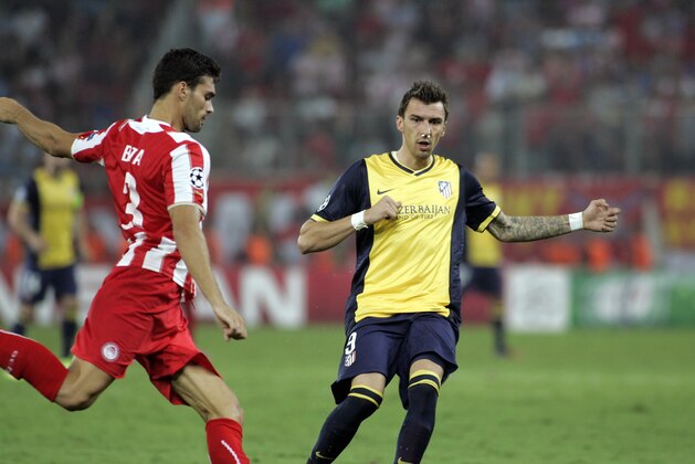 ATHENS, GREECE - SEPTEMBER 16:   Olympiacos Alberto Botia, right, is challenged by Atletico's Mario Mandzukic during  the Champions League Group A soccer match between Olympiakos and Atletico Madrid at Georgios Karaiskakis Stadium in  Piraeus near Athens, Tuesday, Sept. 16, 2014.   (Photo by Milos Bicanski/Getty Images)