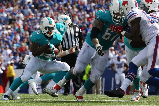 ORCHARD PARK, NY - SEPTEMBER 14:   Damien Williams #34 of the Miami Dolphins runs the ball against the Buffalo Bills during the second half at Ralph Wilson Stadium on September 14, 2014 in Orchard Park, New York.  (Photo by Tom Szczerbowski/Getty Images)