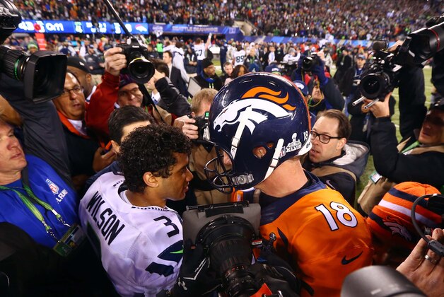 Feb 2, 2014; East Rutherford, NJ, USA; Seattle Seahawks quarterback Russell Wilson (3) shakes hands with Denver Broncos quarterback Peyton Manning (18) after Super Bowl XLVIII at MetLife Stadium.  Mandatory Credit: Mark J. Rebilas-USA TODAY Sports