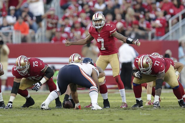 San Francisco 49ers quarterback Colin Kaepernick (7) gestures at the line of scrimmage as offensive tackle Alex Boone (75) and guard Mike Iupati (77) prepare to block during an NFL football game against the Chicago Bears in Santa Clara, Calif., Sunday, Sept. 14, 2014. (AP Photo/Marcio Jose Sanchez)