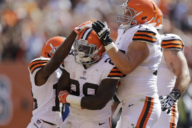 Cleveland Browns running back Terrance West is mobbed by teammates after a 9-yard touchdown run -as- in the third quarter of an NFL football game Sunday, Sept. 14, 2014, in Cleveland. (AP Photo/Tony Dejak)