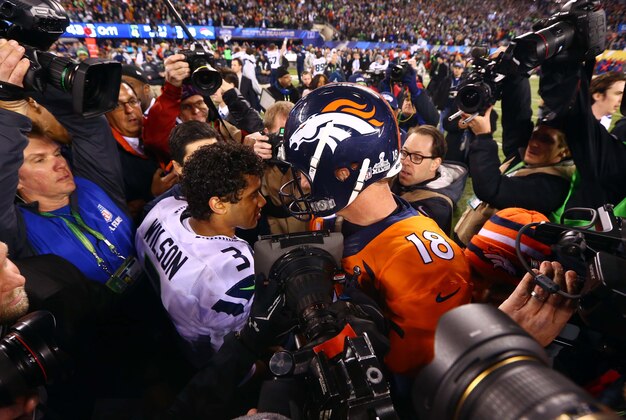Feb 2, 2014; East Rutherford, NJ, USA; Seattle Seahawks quarterback Russell Wilson (3) shakes hands with Denver Broncos quarterback Peyton Manning (18) after Super Bowl XLVIII at MetLife Stadium.  Mandatory Credit: Mark J. Rebilas-USA TODAY Sports