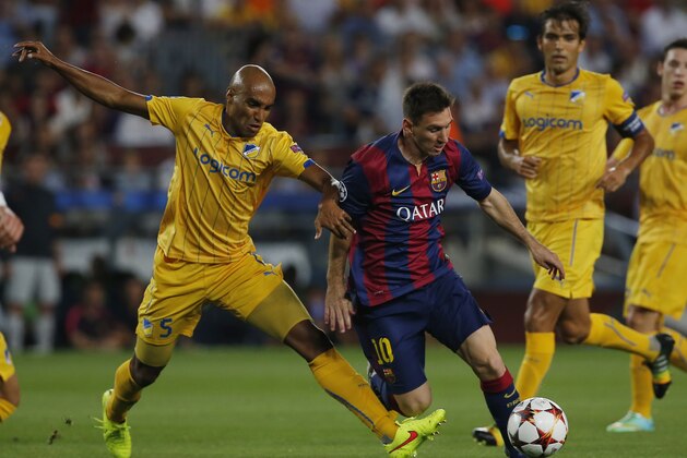 Barcelona's Lionel Messi, left, keeps the ball as APOEL's Da Cruz Junior tries to stop him during the Champions League Group F soccer match between Barcelona and Apoel at the Camp Nou stadium in Barcelona, Spain, Wednesday, Sept. 17, 2014. (AP Photo/Emilio Morenatti)