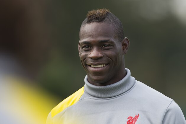 Liverpool's Mario Balotelli smiles as he trains with teammates at Melwood training ground, in Liverpool, Monday, Sept. 15, 2014. Liverpool will play Ludogorets in a Champion's League Group B soccer match on Tuesday. (AP Photo/Jon Super)