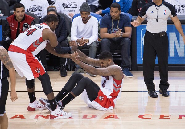 Apr 30, 2014; Toronto, Ontario, CAN; Toronto Raptors forward Patrick Patterson (54) helps up Toronto Raptors forward Amir Johnson (15) in game five of the first round of the 2014 NBA Playoffs against the Brooklyn Nets at Air Canada Centre. The Toronto Raptors won 115-113.Mandatory Credit: Nick Turchiaro-USA TODAY Sports