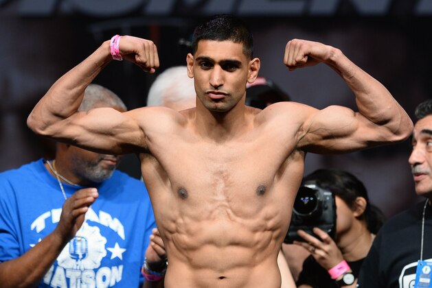 LAS VEGAS, NV - MAY 02:  Boxer Amir Khan poses on the scale during his official weigh-in at the MGM Grand Garden Arena on May 2, 2014 in Las Vegas, Nevada. Khan will meet Luis Collazo in a welterweight bout on May 3.  (Photo by Ethan Miller/Getty Images)