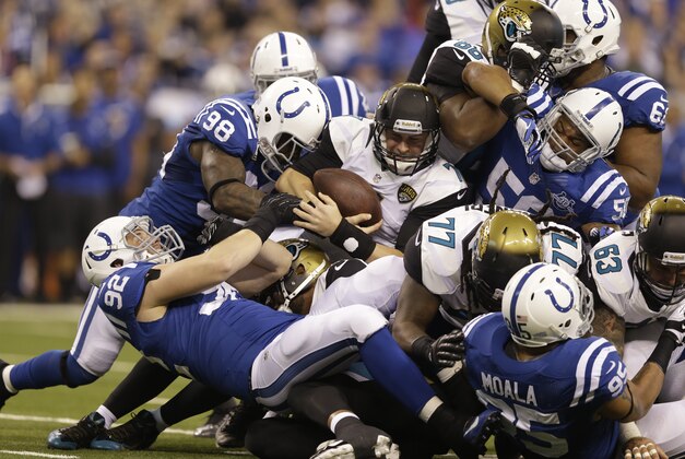Jacksonville Jaguars' Chad Henne (7) is tackled by Indianapolis Colts' Robert Mathis (98) and Bjoern Werner (92) on a third down play during the first half of an NFL football game Sunday, Dec. 29, 2013, in Indianapolis. The Jaguars is not get the first down on the play. (AP Photo/Michael Conroy)