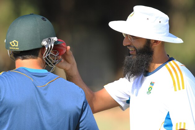 South African captain Hashim Amla, right,  chats to Dean Elgar during a practice session at Harare Sports club, Friday, Aug. 8, 2014, ahead of their one off test match against Zimbabwe  on Saturday. The South Africans will also play ODIs and play in a triangular series which will feature Australia in Harare.(AP Photo/Tsvangirayi Mukwazhi)