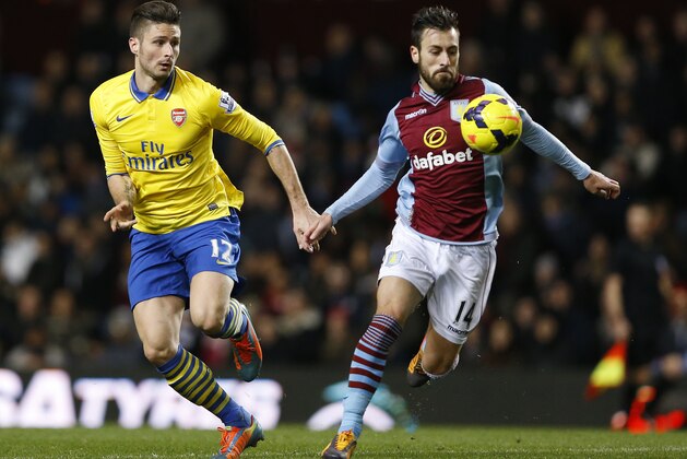 Aston Villa's Antonio Luna, right chefs the ball away from Arsenal's Oliver Giroud during the English Premier League soccer match between Aston Villa and Arsenal at Villa Park stadium in Birmingham, England, Monday, Jan. 13, 2014. Arsenal won the game 2-1.(AP Photo/Kirsty Wigglesworth)