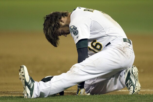 Oakland Athletics' Josh Reddick attempts to stand after falling on a run to first base in the eighth inning of a baseball game against the Texas Rangers Wednesday, Sept. 17, 2014, in Oakland, Calif. (AP Photo/Ben Margot)