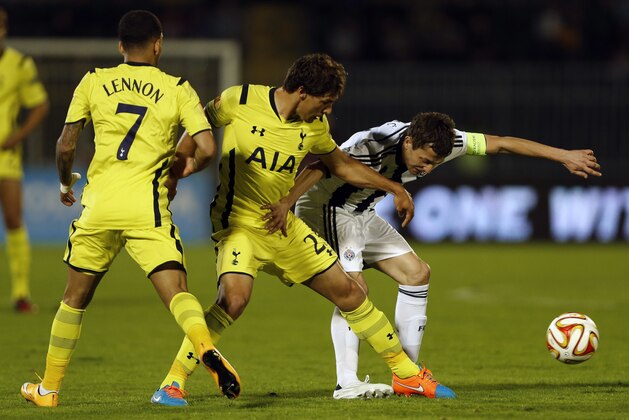 Partizan Belgrade's Sasa Ilic, right, is challenged by Tottenham Hotspur's Benjamin Stambouli, center, while Tottenham Hotspur's Aaron Lennon watches the action during the Europa League Group C soccer match between Partizan Belgrade and Tottenham Hotspur in Belgrade, Serbia, Thursday, Sept. 18, 2014. (AP Photo/Marko Drobnjakovic)