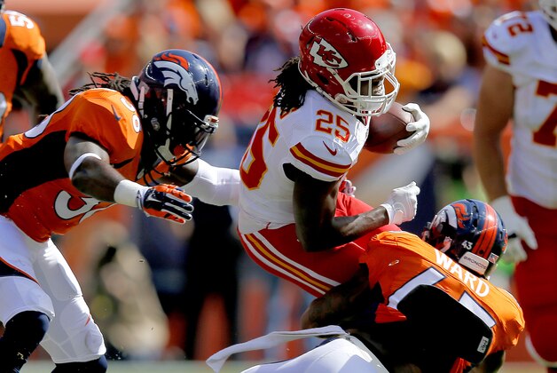 Kansas City Chiefs running back Jamaal Charles (25) is tripped up by Denver Broncos strong safety T.J. Ward (43) and Quinton Carter during the first half of an NFL football game, Sunday, Sept. 14, 2014, in Denver. (AP Photo/Jack Dempsey)