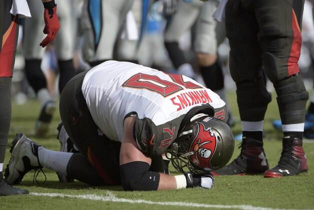 Tampa Bay Buccaneers guard Logan Mankins (70) kneels on the ground after sustaining an injury during the first half of an NFL football game against the Carolina Panthers in Tampa, Fla., Sunday, Sept. 7, 2014.(AP Photo/Phelan M. Ebenhack)