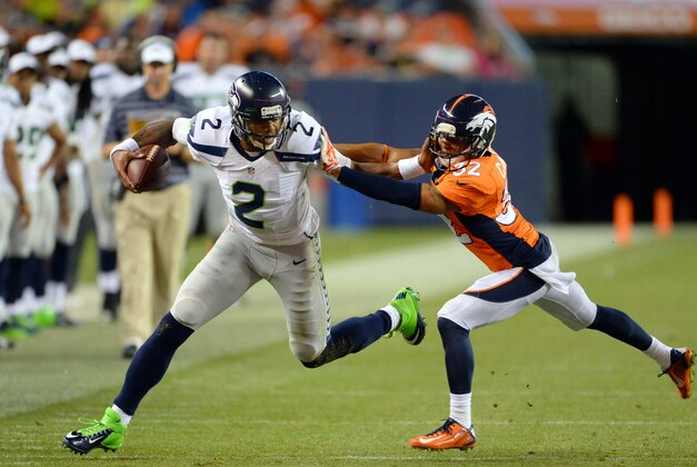 Aug 7, 2014; Denver, CO, USA; Denver Broncos cornerback Tony Carter (32) attempts to tackle Seattle Seahawks quarterback Terrelle Pryor (2) in the fourth quarter of a preseason game at Sports Authority Field at Mile High. The Broncos defeated the Seahawks 21-16. Mandatory Credit: Ron Chenoy-USA TODAY Sports