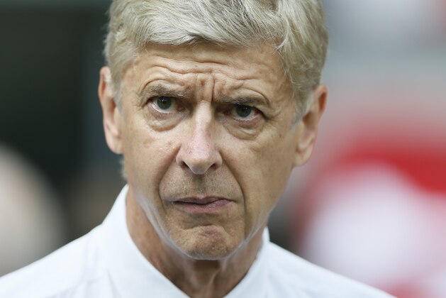 Arsenal's manger Arsene Wenger watches his players wait to go up and collect the trophy after defeating Manchester City 3-0, during the English FA Community Shield soccer match at Wembley Stadium, London Sunday, Aug. 10, 2014. (AP Photo/Alastair Grant)
