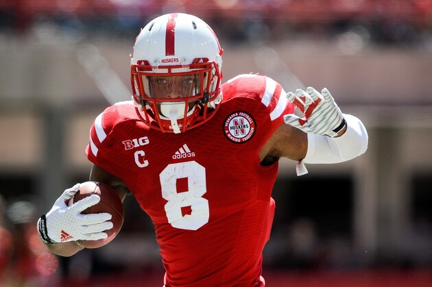LINCOLN, NE - SEPTEMPER 6: Running back Ameer Abdullah #8 of the Nebraska Cornhuskers runs past linebacker Ashari Goins #49 of the McNeese State Cowboys during their game at Memorial Stadium on September 6, 2014 in Lincoln, Nebraska. Nebraska defeated McNeese State 31-24. (Photo by Eric Francis/Getty Images)