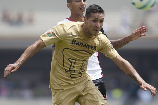Pumas´ Ismael Sosa, front, compete for the ball with Atlas´ Edgar Catillo  during a Mexican soccer league match in Mexico City, Sunday, Aug.  10, 2014. (AP Photo/Christian Palma)