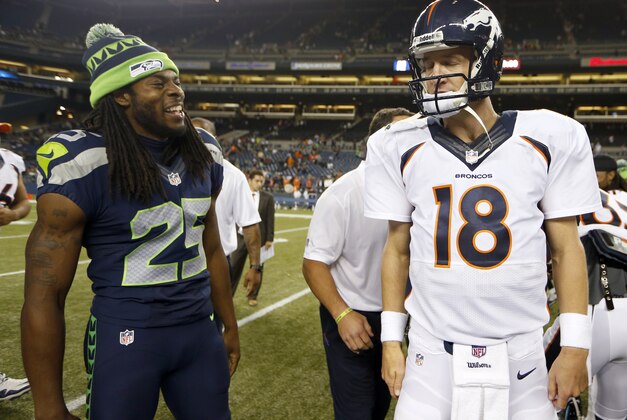 In this photo taken Aug. 17, 2013, Denver Broncos quarterback Peyton Manning (18) walks away after shaking hands with Seattle Seahawks cornerback Richard Sherman, left, after the Seahawks beat the Broncos 40-10, in a preseason NFL football game in Seattle. The two teams square off in Super Bowl XLVIII on Sunday, Feb. 2, 2014, in East Rutherford, N.J.   (AP Photo/John Froschauer)
