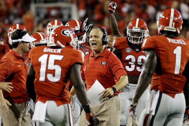 Georgia head coach Mark Richt, center, talks to his players as a Georgia fumble recovery is under review in the second half of an NCAA college football game against Clemson, Saturday, Aug. 30, 2014, in Athens, Ga. The play was reversed ruling in favor of Clemson as Georgia went on to win 45-21. (AP Photo/David Goldman)