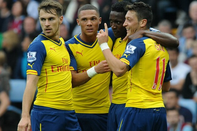 Arsenal's Mesut Ozil, right, celebrates with Aaron Ramsey, left, Alex Oxlade-Chamberlain, second left, and Danny Welbeck after scoring against Villa during the English Premier League soccer match between Aston Villa and Arsenal at Villa Park, Birmingham, England, Saturday, Sept. 20, 2014. (AP Photo/Rui Vieira)