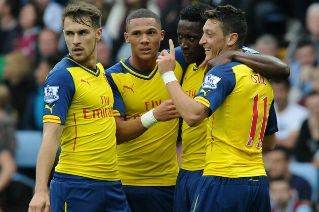 Arsenal's Mesut Ozil, right, celebrates with Aaron Ramsey, left, Alex Oxlade-Chamberlain, second left, and Danny Welbeck after scoring against Villa during the English Premier League soccer match between Aston Villa and Arsenal at Villa Park, Birmingham, England, Saturday, Sept. 20, 2014. (AP Photo/Rui Vieira)