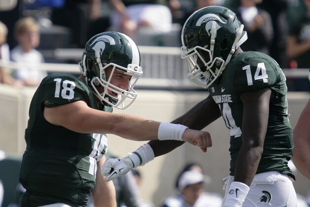 Michigan State quarterback Connor Cook (18) and receiver Tony Lippett (14) celebrate Lippett's touchdown reception against Eastern Michigan during the first quarter of an NCAA college football game, Saturday, Sept. 20, 2014, in East Lansing, Mich. (AP Photo/Al Goldis)
