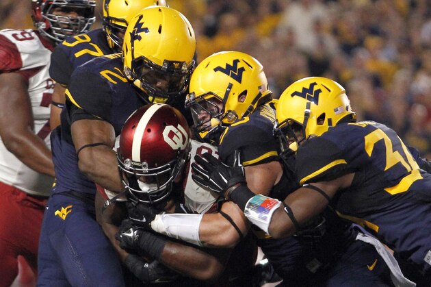 MORGANTOWN, WV - SEPTEMBER 20:  Samaje Perine #32 of the Oklahoma Sooners is stopped by Brandon Golson #2 and Ishmael Banks #34 of the West Virginia Mountaineers in the first half during the game on September 20, 2014 at Mountaineer Field in Morgantown, West Virginia.  (Photo by Justin K. Aller/Getty Images)