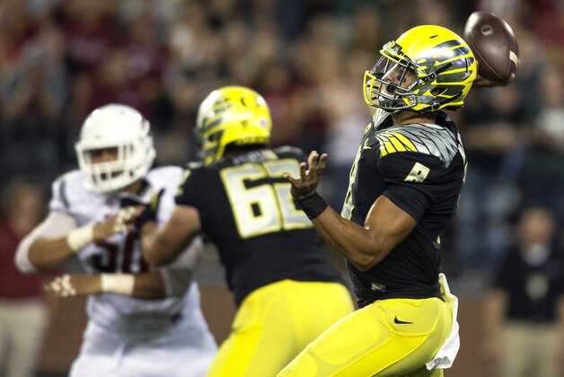 Oregon quarterback Marcus Mariota (8) throws a touchdown pass to wide receiver Devon Allen against Washington State during the first quarter of an NCAA college football game Saturday, Sept. 20, 2014, in Pullman, Wash. (AP Photo/Dean Hare)